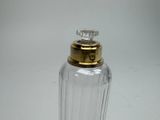 a clear glass bottle with a gold top