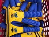 des tuyaux jaunes et bleus dans un panier rouge posé sur une table