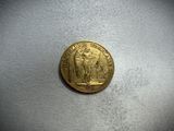 a gold coin sitting on top of a white surface