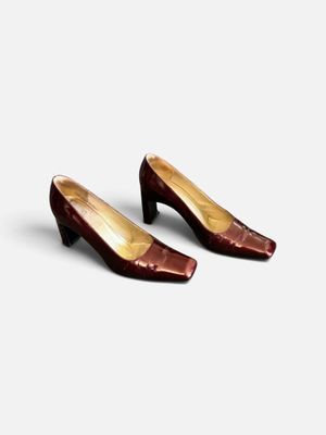 une paire de chaussures marron posée sur une surface blanche