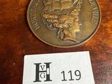 une pièce de monnaie posée sur une table, sur laquelle est posé un badge nominatif
