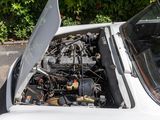 a white car with the hood open and the engine in the trunk