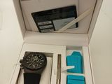 a box with a watch, pen, and other items in it