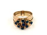 Gros plan sur une bague en or ornée de pierres bleues