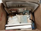 a cardboard box full of books and papers on the floor