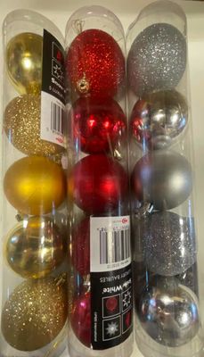de nombreuses décorations de Noël de différentes couleurs dans un récipient transparent