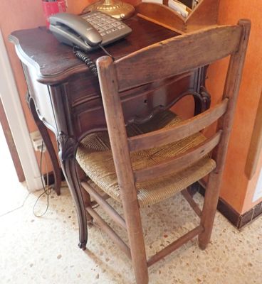un bureau avec un téléphone et une chaise devant