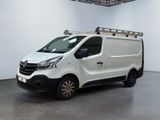 La camionnette blanche est garée dans une grande pièce, avec une échelle sur le toit.
