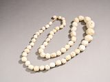 an image of a white beaded necklace on a gray surface