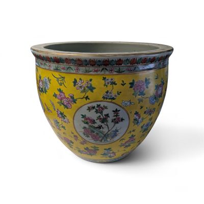 a yellow vase with flowers on it on a white background