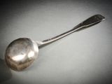 une cuillère en argent avec un manche de cuillère sur une table