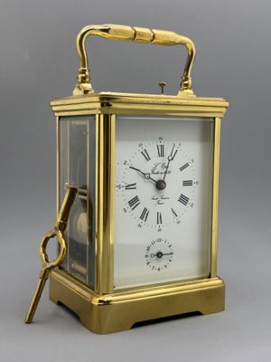 an image of a gold clock with a key on top of it