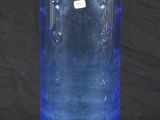 a blue glass vase that is sitting on a table