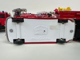 two toy firetrucks sitting next to each other on a table
