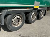 un semi-remorque vert garé sur un parking
