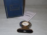 a small clock sitting on a table next to a blue box