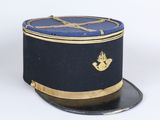 casquette bleu marine avec une bordure dorée et un poisson sur le devant