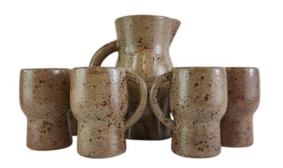 cinq tasses et un pichet posés sur une table