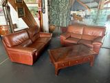 deux canapés en cuir marron et une table basse dans une pièce