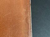 an image of a brown wallet sitting on top of a black table