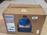 emballage d'un aspirateur Philips dans une boîte en carton posée sur une table
