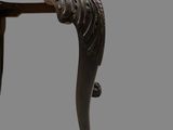 a wooden table with a carved top and legs