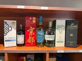 de nombreuses bouteilles d'alcool sur une étagère dans un magasin