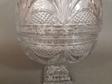 a clear glass bowl on a stand on a table