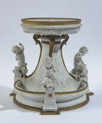 un socle blanc et doré surmonté de statues