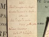 une pile de vieux papiers posée sur une table, à côté d'une paire de ciseaux