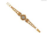 un gros plan d'un bracelet en or orné d'un motif floral