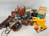 une pile de vieux appareils photo et d'autres objets posés sur une table