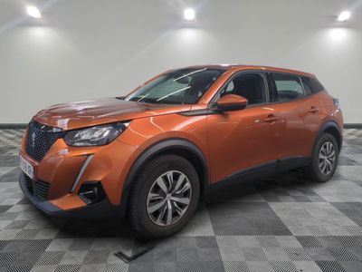 un SUV orange garé sur un sol à damier dans un garage