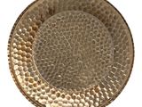 gold hammered metal plate with a circular design on the rim