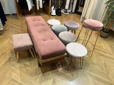 quatre tabourets et un banc au milieu d'une pièce