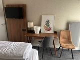 a bed, desk, chair and television in a small room