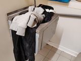 un lavabo dans une salle de bains sur lequel sont suspendus de nombreux vêtements