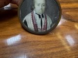 a person holding a miniature picture of a man on a table