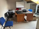 une salle équipée d'un bureau, de chaises et d'un écran de projection