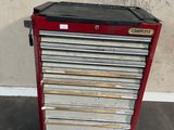 a red and black tool cabinet sitting on top of a cement floor