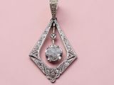 a white diamond pendant on a pink background