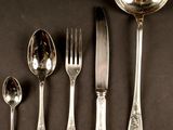 five spoons, a fork, and a spoon on a table