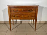 a small wooden chest of drawers on a tiled floor