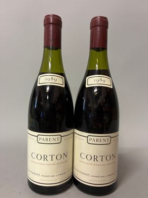 pair of two bottles of red wine sitting on top of a table
