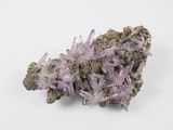 a cluster of purple crystals on a white surface