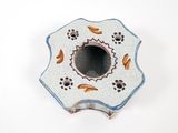 a small white and blue flower shaped object on a white surface