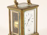 a small brass clock with roman numerals on the face