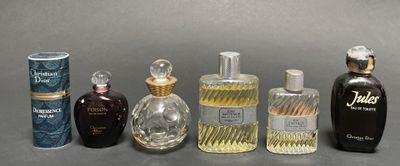 several different types of perfume bottles lined up on a gray surface