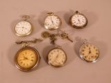 many different types of pocket watches on the table