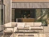 une photo d'une terrasse avec un canapé et une table basse
